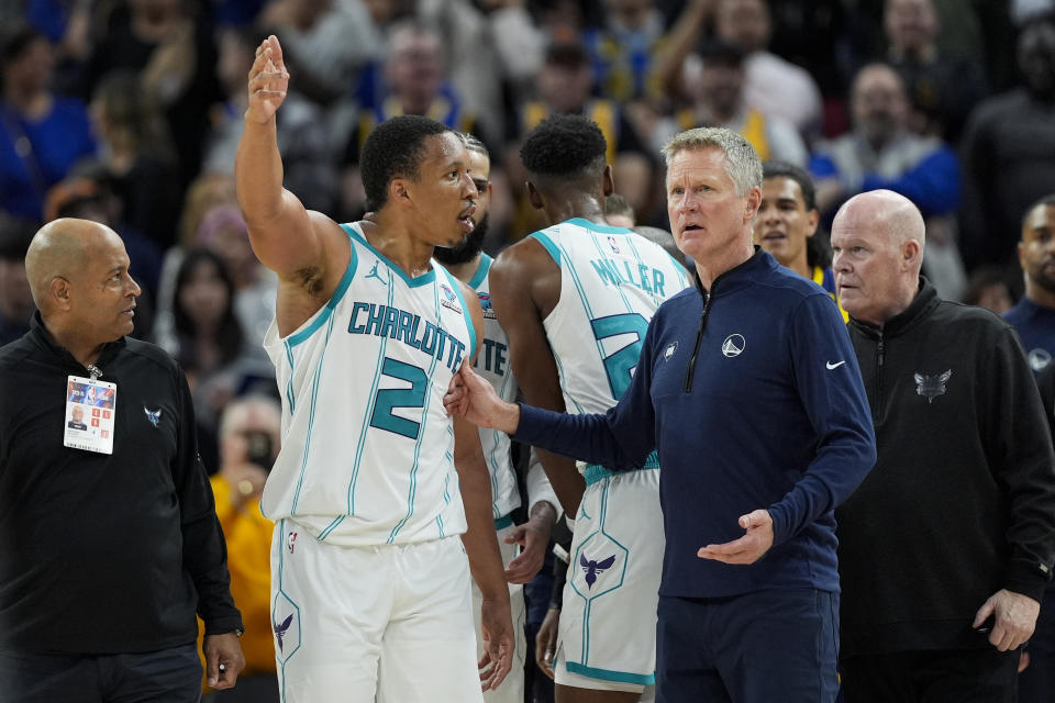 Charlotte Hornets forward Grant Williams (2) speaks to Golden State Warriors head coach Steve Kerr, center right, during the second half of an NBA basketball game, Friday, Feb. 23, 2024, in San Francisco. (AP Photo/Godofredo A. Vásquez)