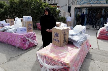 Displaced Iraqi Sunnis fleeing from Islamic State militants in al-Baghdadi district in Anbar provinces, receive aid from the United Nations Refugee Agency (UNHCR) in Baghdad February 24, 2015 REUTERS/Thaier Al-Sudani