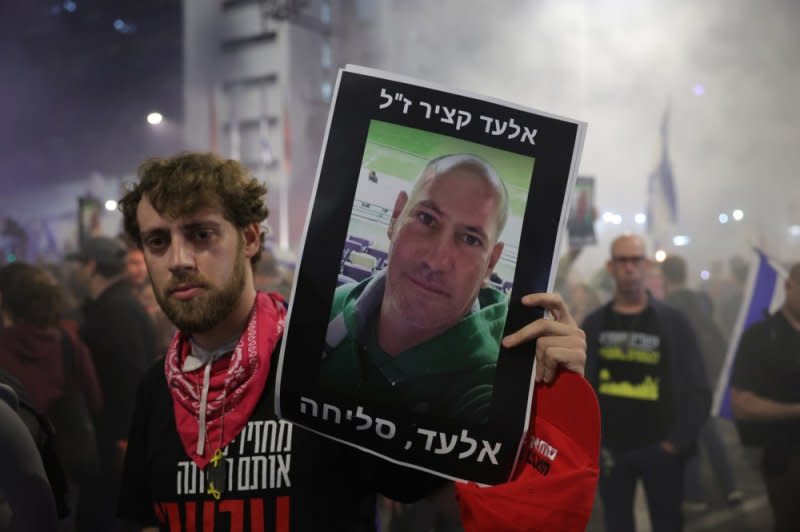 A protestor holds a placard with a picture of deceased hostage, Elad Katzir, outside the Kirya military headquarters in Tel Aviv. Photo by Abir Sultan/EPA-EFE