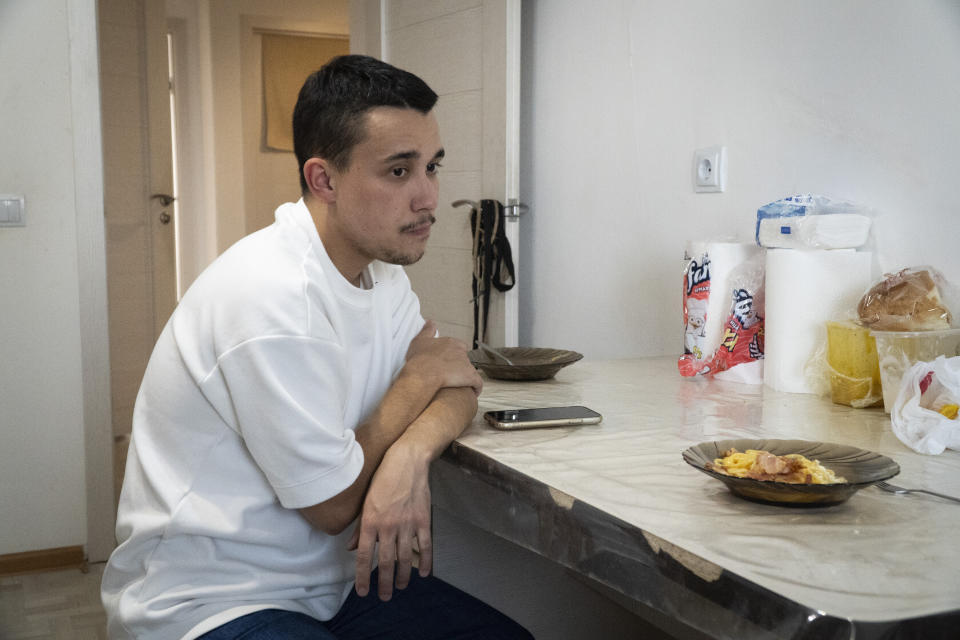 Farhad Ziganshin, a Russian officer who deserted in 2022, sits at a table after lunch at his temporary apartment in Astana, Kazakhstan, in late 2023. "I realized that I didn't want to serve in this kind of Russian army that destroys cities, kills civilians, and forcibly appropriates foreign land and territory," he said. (AP Photo)