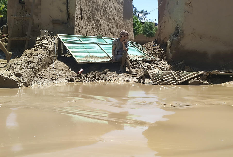 A man sits near his damaged house after heavy flooding in Baghlan province, in northern Afghanistan, Sunday, May 12, 2024. Victims of the devastating floods in northern Afghanistan are burying the dead and looking for the loved ones still missing. (AP Photo)