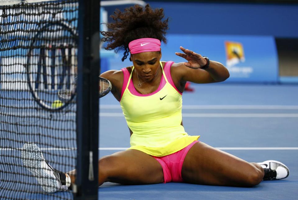 Serena Williams of the U.S. reacts as she slips while chasing after a ball during her women's singles first round match against Alison Van Uytvanck of Belgium at the Australian Open 2015 tennis tournament in Melbourne January 20, 2015. REUTERS/Issei Kato (AUSTRALIA - Tags: SPORT TENNIS)