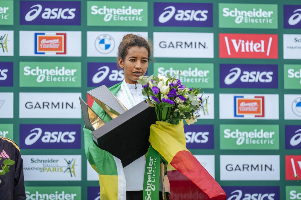 Mestawut Fikir of Ethiopia holds her trophy on the podium after winning the women's race of the Paris marathon, in Paris, Sunday, April 7, 2024. (AP Photo/Lewis Joly)