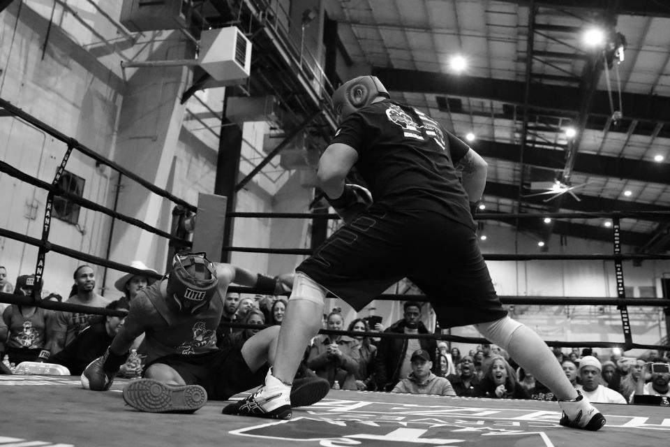 <p>Lt. Darryl Knight lands a punch that knocks down Detective Ariel Marte during a tag team match at the “Bronx Tough Turkey Tussle” in the Hunts Point section of the Bronx, New York, on Nov. 16, 2017. (Photo: Gordon Donovan/Yahoo News) </p>