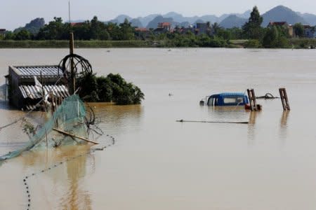 A submerged truck and houses are seen at a flooded village after a heavy rainfall caused by a tropical depression in Ninh Binh province, Vietnam October 14, 2017. REUTERS/Kham