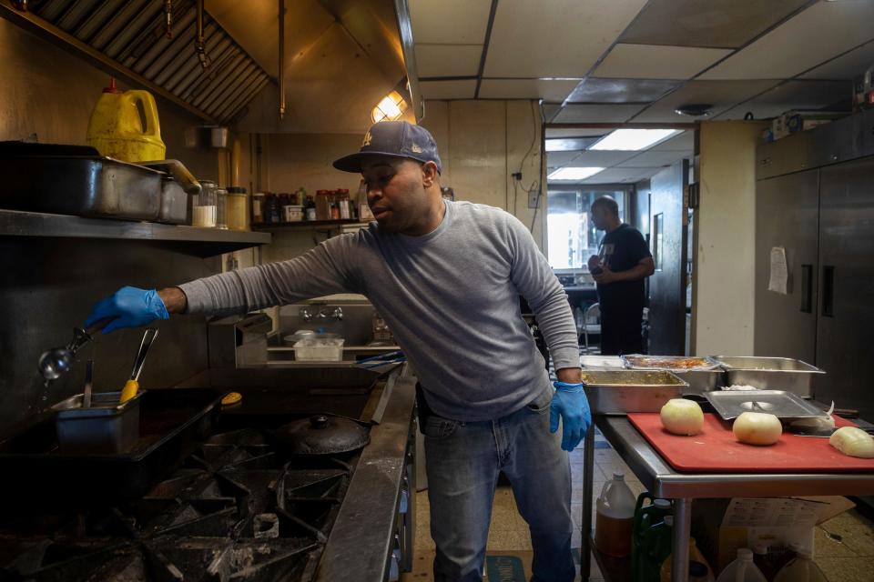 Gregory Beard Jr., 35, co-owner of Soul-N-The Wall, prepares a chicken wings and turkey chop dinner for a customer inside the restaurant's kitchen in Detroit on Wednesday, June 21, 2023.