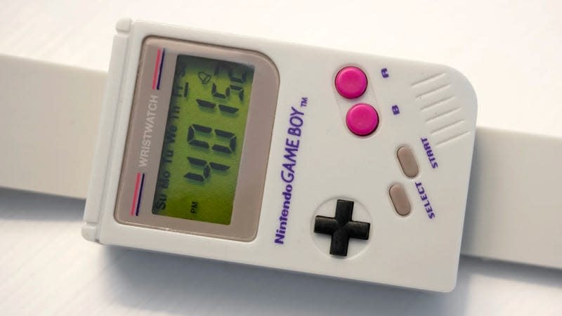 A closeup of the Paladone Game Boy digital watch, photographed on a white wood side table.