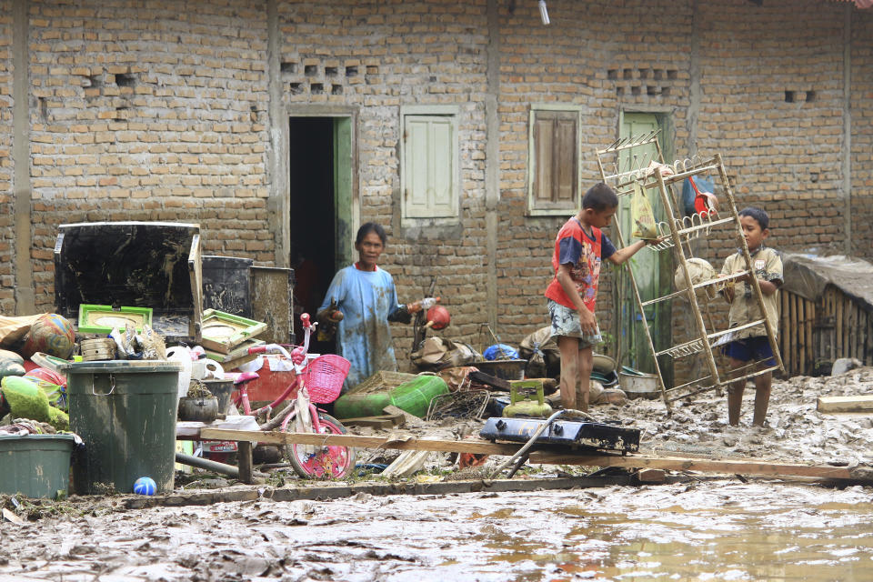 Residents clean up their flood-damaged house in Central Tapanuli, North Sumatra, Indonesia Wednesday, Jan. 29, 2020. Landslides and floods from torrential rains in Indonesia' Sumatra island leave a scores of people dead and displaced thousands, the country's disaster agency said Wednesday. (AP Photo/Damai Mendrofa)