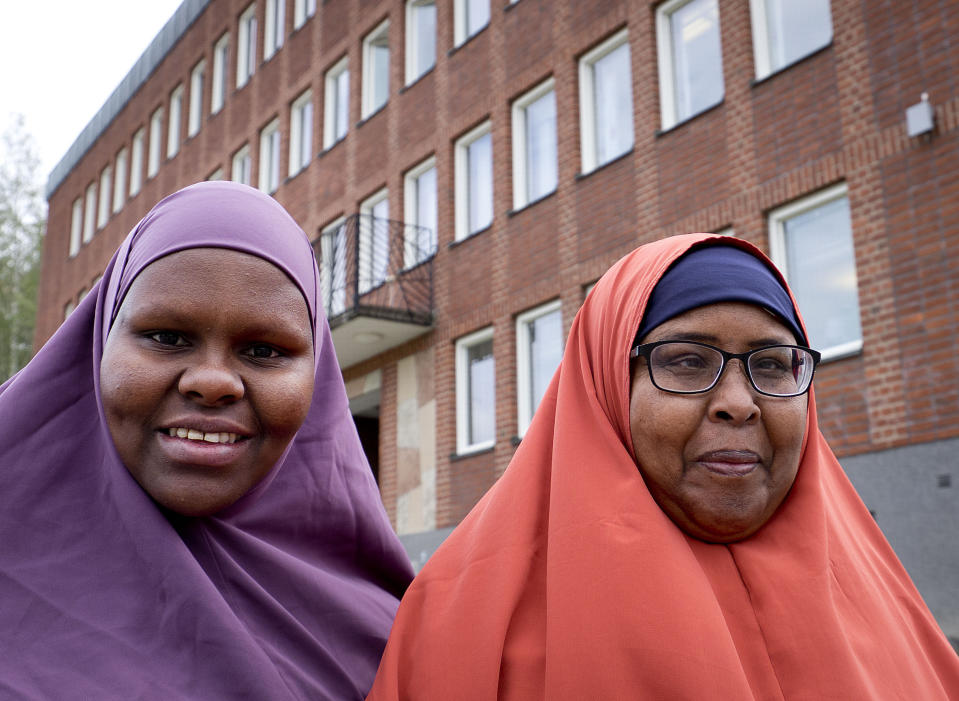 In this Aug. 30, 2018 photo Marian Omar, left, and Anab Adan, both from Somalia, pose in front of the town hall in Flen, some 100 km west of Stockholm, Sweden. The town has welcomed so many asylum seekers in recent years that they now make up about a fourth of the population. (AP Photo/Michael Probst)