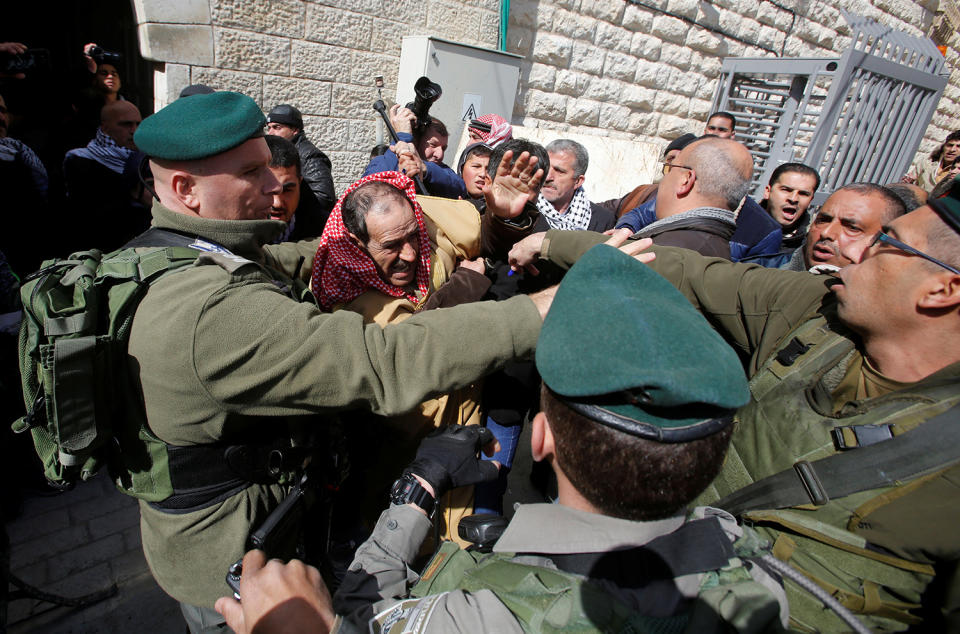 <p>A Palestinian man scuffles with Israeli border policemen during a protest calling for the reopening of a closed street in the West Bank city of Hebron on Feb. 17, 2017. (Photo: Mussa Qawasma/Reuters) </p>