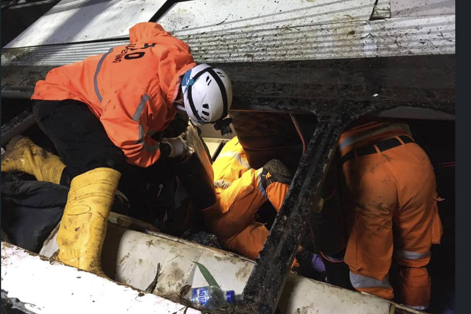 In this photo released by National Search and Rescue Agency (BASARNAS), rescuers search for survivors and victims inside the wreckage of a bus that plunged into a ravine in Sumedang West Java, Indonesia, Thursday, March 11, 2021. The tourist bus plunged into the ravine after its brakes apparently malfunctioned, killing a number of people, police and rescuers said. (BASARNAS via AP)