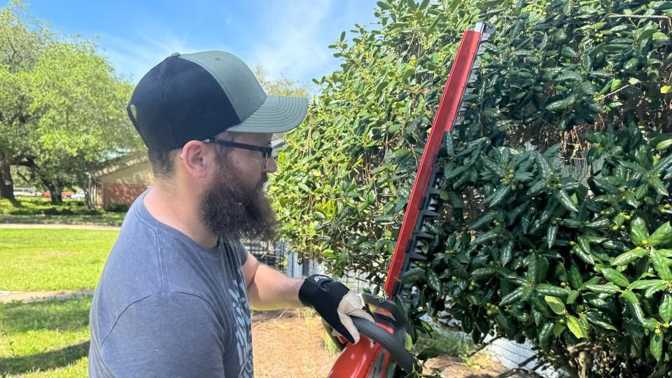Jason Cockerham using the Husqvarna Hedge Master 320iHD60 to trim hedges while on test