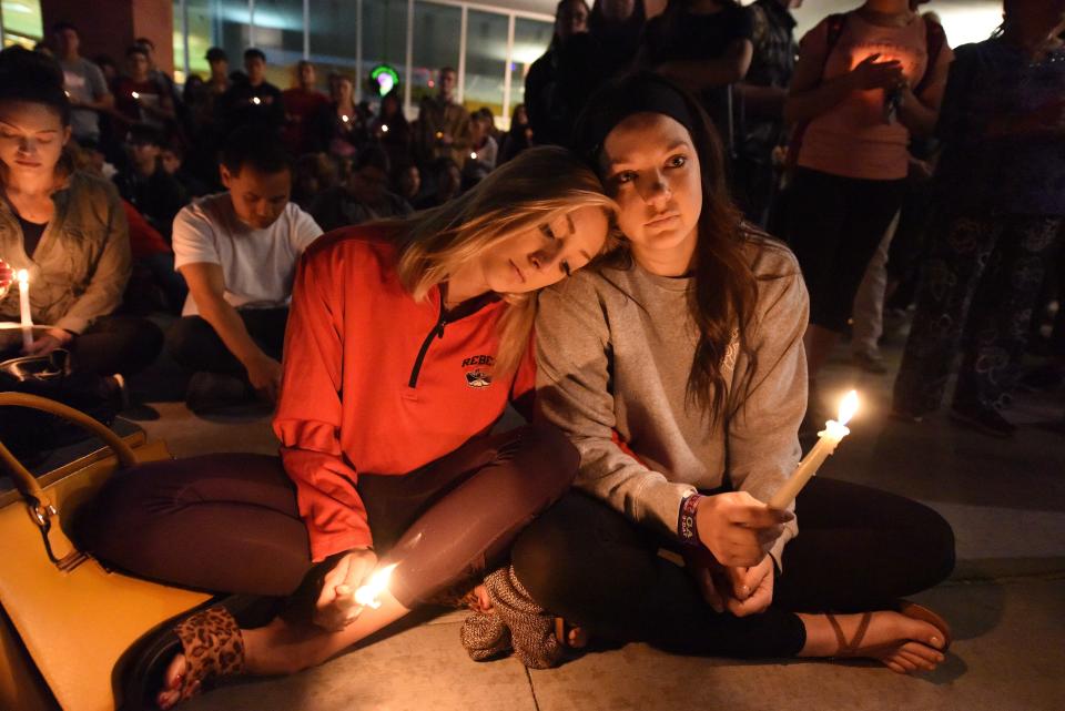 <p>Lindsay Cotterman (L) and Shawna Pieruschka attend a candlelight vigil at the University of Las Vegas student union October 2, 2017, after a gunman killed at least 58 people and wounded more than 500 others when he opened fire on a country music concert in Las Vegas, Nevada late October 1, 2017. (Photo: Robyn Beck/AFP/Getty Images) </p>