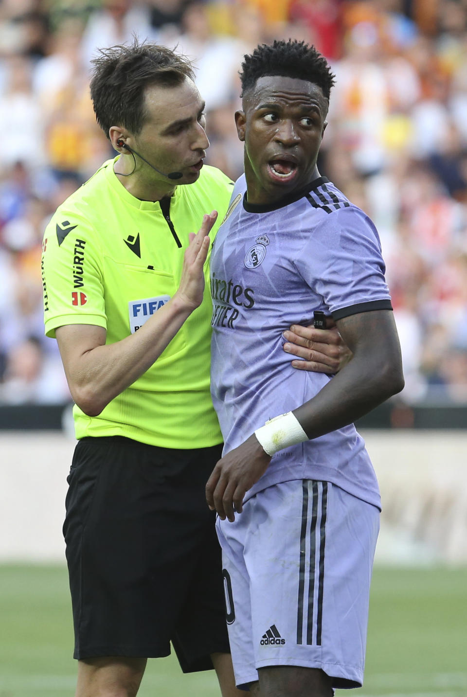 Referee Ricardo De Burgos Bengoetxea, left, speaks with Real Madrid's Vinicius Junior during a Spanish La Liga soccer match between Valencia and Real Madrid, at the Mestalla stadium in Valencia, Spain, Sunday, May 21, 2023. The game was temporarily stopped when Vinicius said a fan had insulted him from the stands. He was later sent off after clashing with Valencia players. (AP Photo/Alberto Saiz)