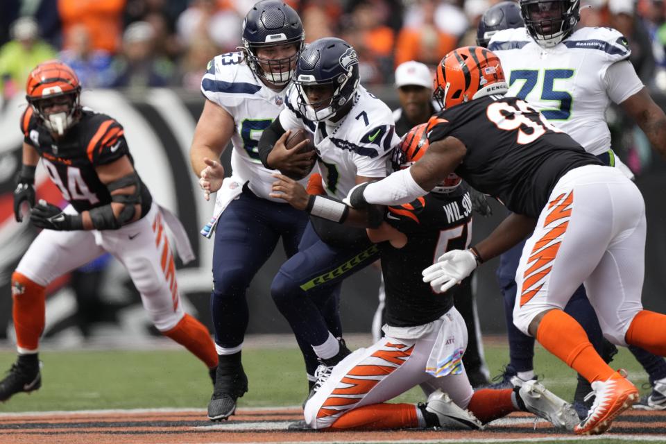 Seattle Seahawks quarterback Geno Smith (7) is tackled by Cincinnati Bengals' Logan Wilson (55) during the first half of an NFL football game, Sunday, Oct. 15, 2023, in Cincinnati. (AP Photo/Carolyn Kaster)