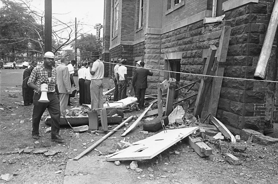 A civil defense worker and firemen walk through debris from an explosion which struck the 16th Street Baptist Church, killing and injuring several people, in Birmingham, Ala. on Sept. 15, 1963. The open doorway at right is where four young girls were killed and another lost an eye.