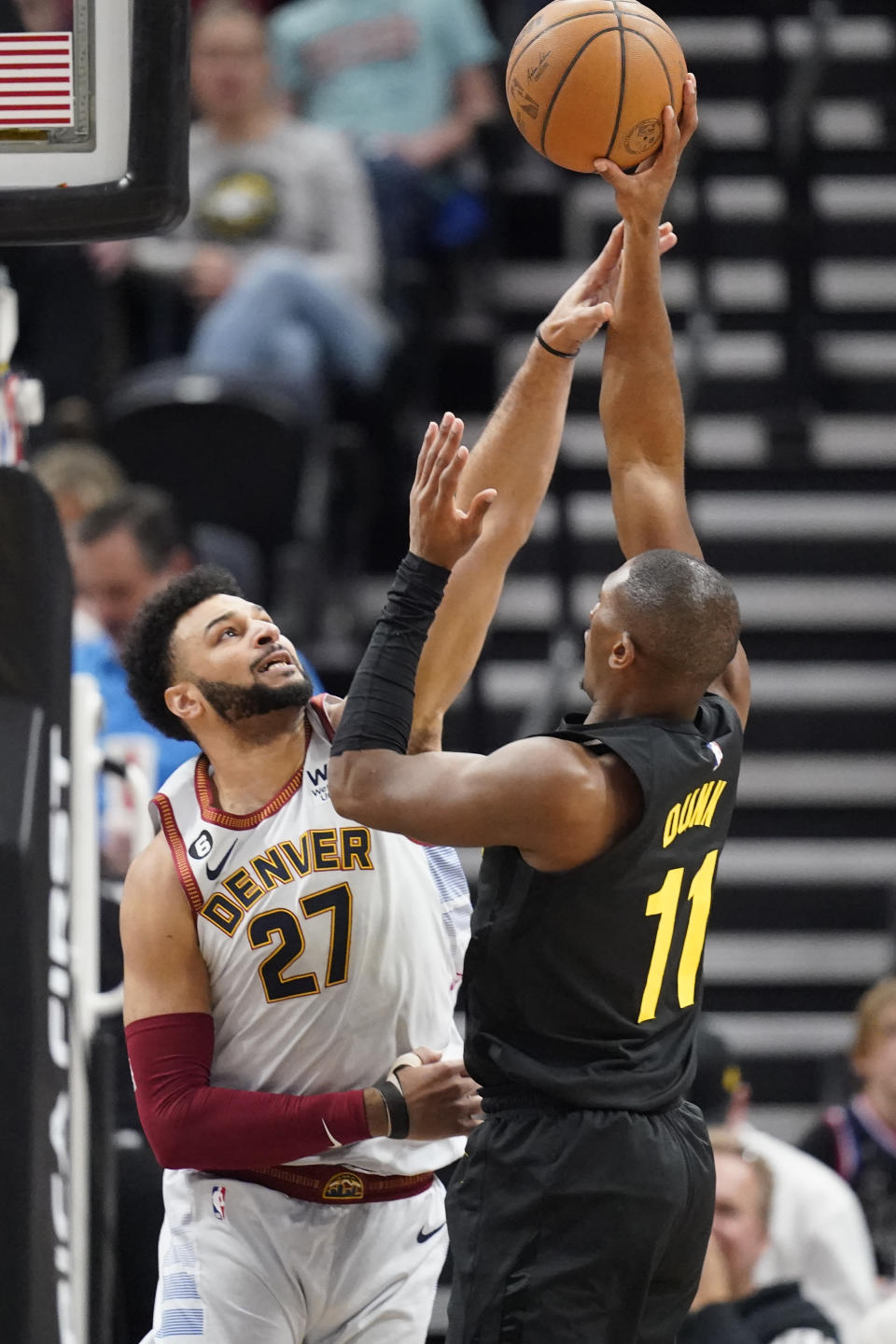 Utah Jazz guard Kris Dunn (11) shoots as Denver Nuggets guard Jamal Murray (27) defends during the first half of an NBA basketball game Saturday, April 8, 2023, in Salt Lake City. (AP Photo/Rick Bowmer)