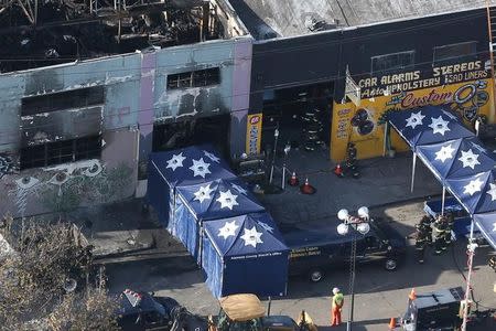 A coroner's truck is seen outside the burned warehouse following the fatal fire in the Fruitvale district of Oakland, California, U.S. December 4, 2016. REUTERS/Lucy Nicholson