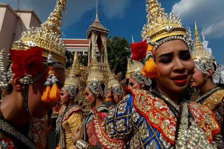 Traditional dancers stand next to the Great Victory Royal Chariot that will carry the late King Bhumibol Adulyadej's body in a giant ornate urn to the cremation site, in Bangkok, Thailand, September 21, 2017. REUTERS/Athit Perawongmetha