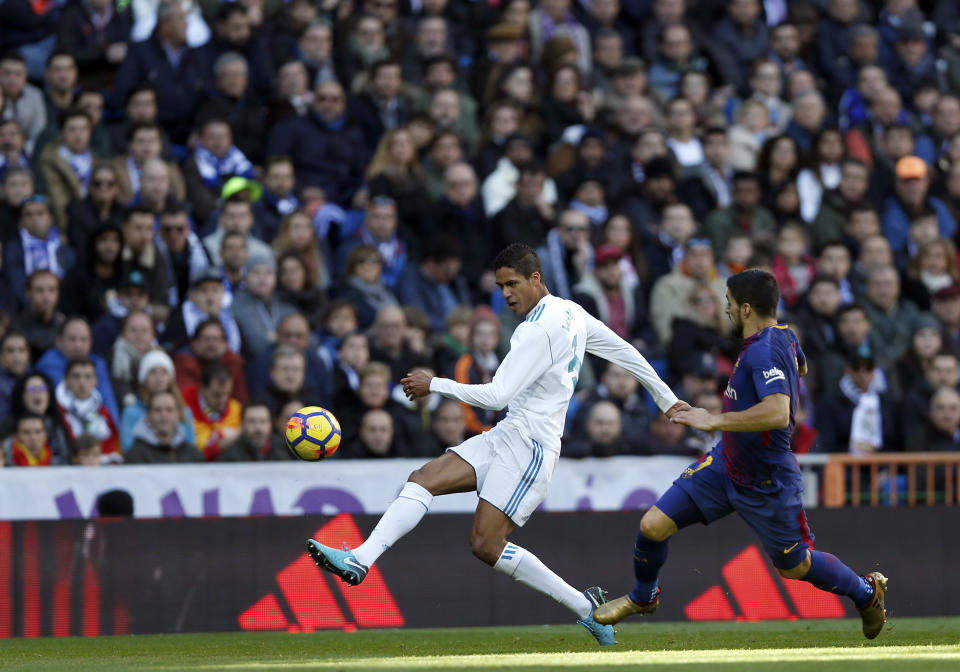 <p>Real Madrid’s Raphael Varene clears the ball away from Luis Suarez </p>