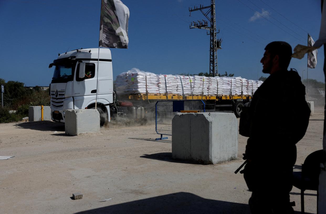 An Israeli soldier stands guard as a truck carrying humanitarian aid is seen near the Erez crossing in southern Israel (REUTERS)