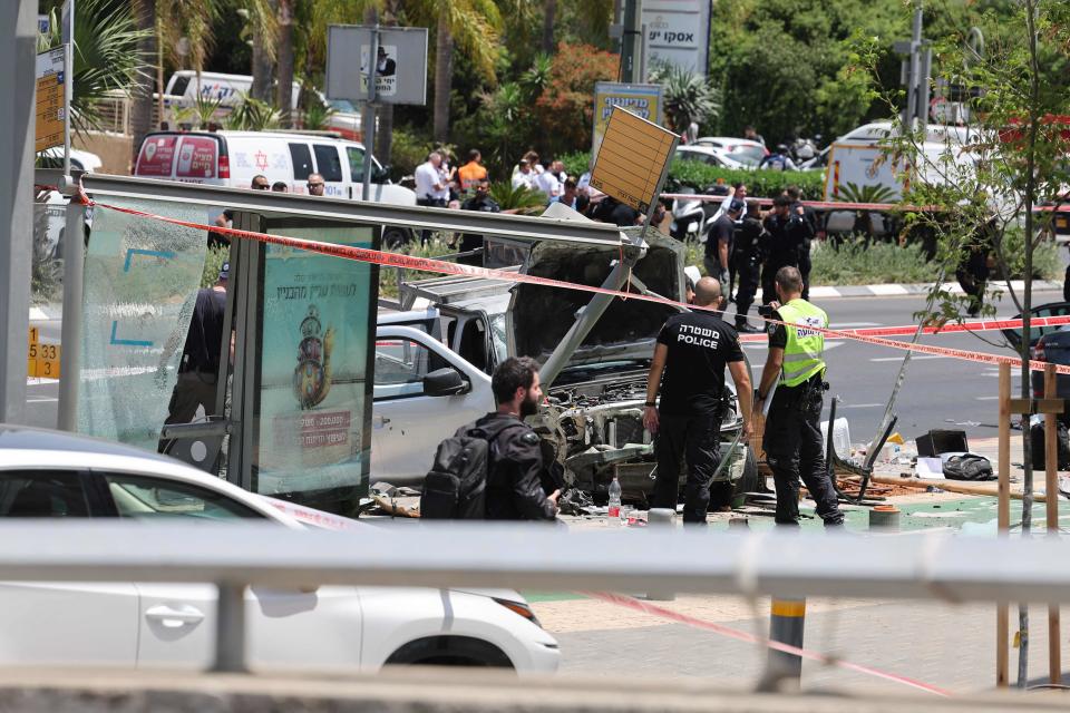 Israeli security and emergency personnel work at the site of a reported car ramming attack in Tel Avi (AFP via Getty Images)