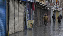 FILE - In this Saturday, Jan. 16, 2021 file photo, people walk past closed shops in London, during England's third national lockdown since the coronavirus outbreak began. Thanks to an efficient vaccine roll out program and high uptake rates, Britain is finally saying goodbye to months of tough lockdown restrictions. From Monday May 17, 2021, all restaurants and bars can fully reopen, as can hotels, cinemas, theatres and museums, and for the first time since March 2020, Britons can hug friends and family and meet up inside other people’s houses. (AP Photo/Frank Augstein, File)