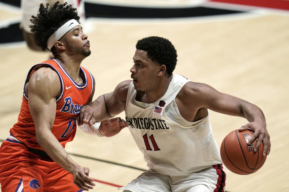 San Diego State forward Matt Mitchell (11) drives the ball against Boise State guard Marcus Shaver Jr. (0) during the first half of an NCAA college basketball game Saturday, Feb 27, 2021, in San Diego. (AP Photo/Gregory Bull)