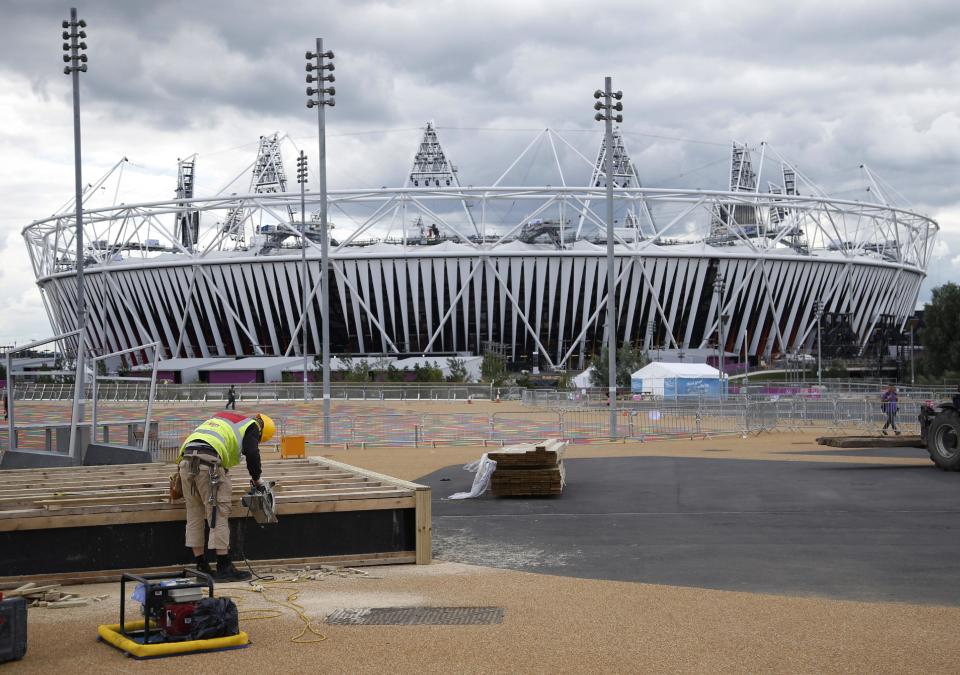 A construction worker builds a stand outside the Olympic Stadium as preparations continue for the 2012 Summer Olympics, Sunday, July 15, 2012, in London. (AP Photo/Jae Hong)