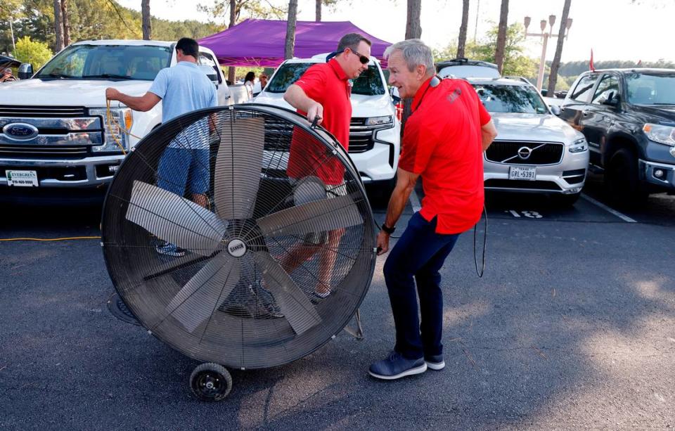 Steve Knier, right, and Brian Burns move a 48-inch shop fan as they set up their tailgate before the Carolina Hurricanes’ playoff game against the N.Y. Rangers at PNC Arena Friday, May 20, 2022.