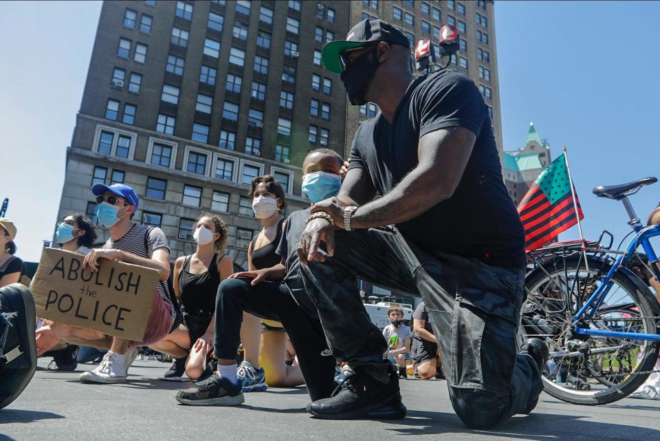 Protesters take a knee at Borough Hall as part of a solidarity rally calling for justice over the death of George Floyd, and to highlight police brutality nationwide, Tuesday, June 9, 2020, in the Brooklyn borough of New York.