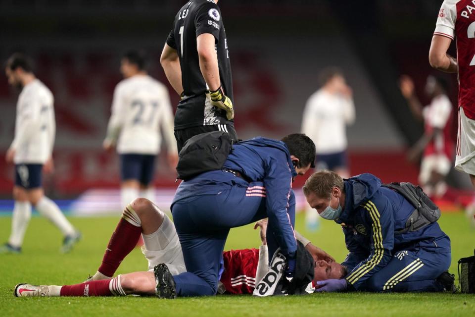 Arsenal’s Rob Holding is treated by the medical team before leaving the game as a concussion substitution (John Walton/PA) (PA Archive)