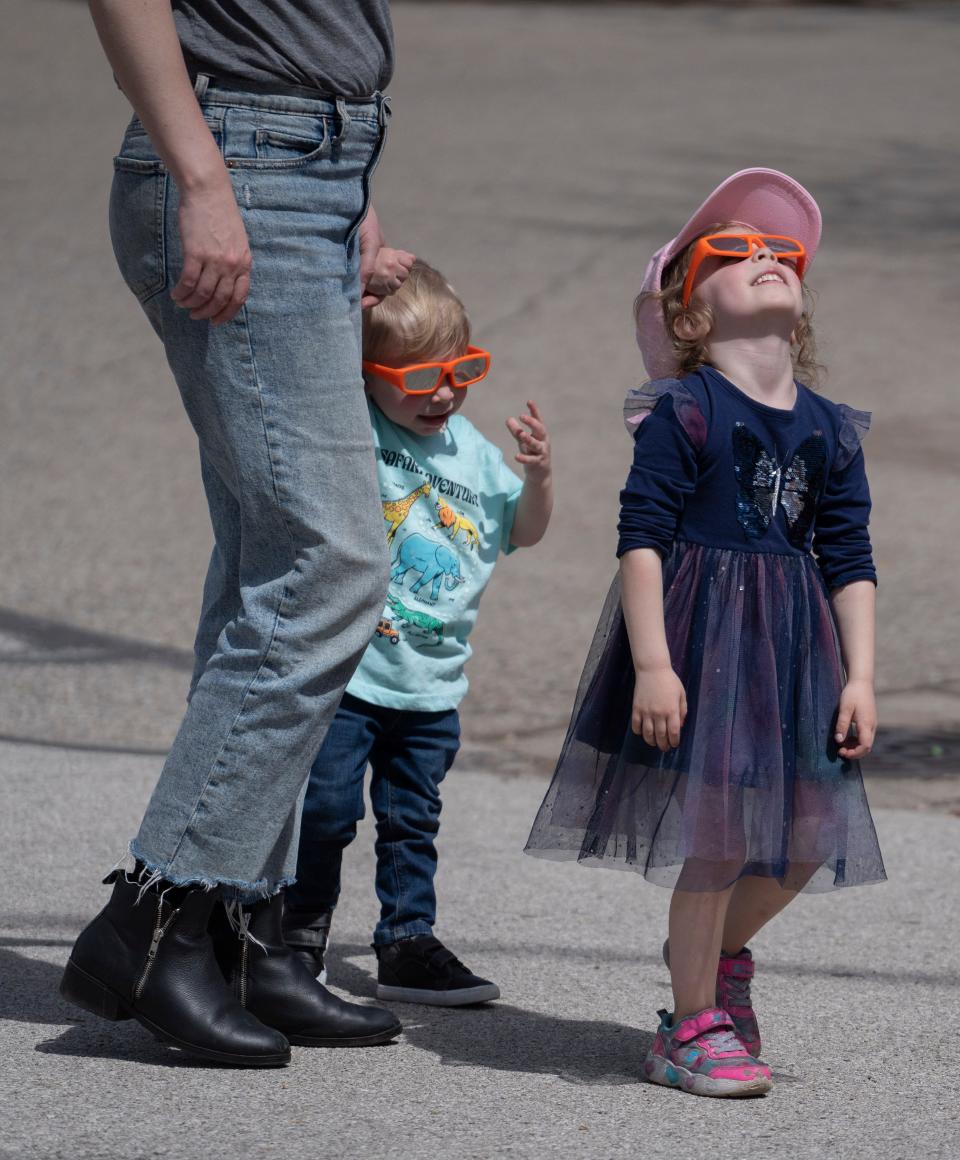 Families watch the eclipse Monday, April 8, 2024 at the Indianapolis Zoo. The Zoo was one location people went to observe the total solar eclipse.