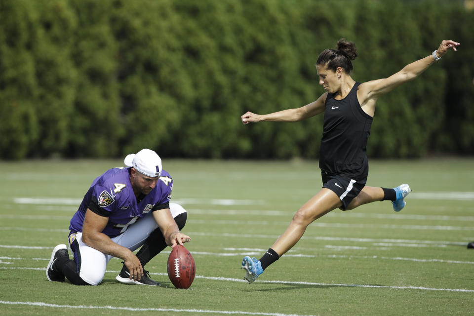 United States soccer player Carli Lloyd attempts to kick a field goal as Baltimore Ravens' Sam Koch holds the ball after a practice in 2019. (AP Photo/Matt Rourke)