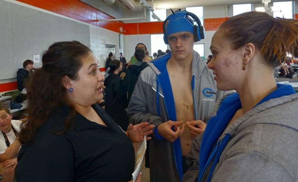 From left-Carlsbad High School swim coach Moranda Madero, Mason Dhenin and Colette Dhenin talk strategy during a Jan. 13, 2024 swim meet in Artesia.