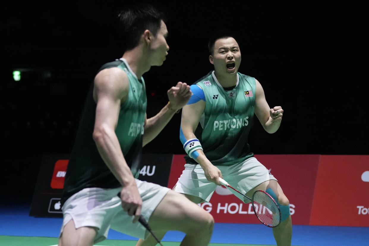 Malaysian men's doubles duo Aaron Chia (right) and Soh Wooi Yik celebrate winning a point during the 2022 BWF World Championships final in Tokyo. 