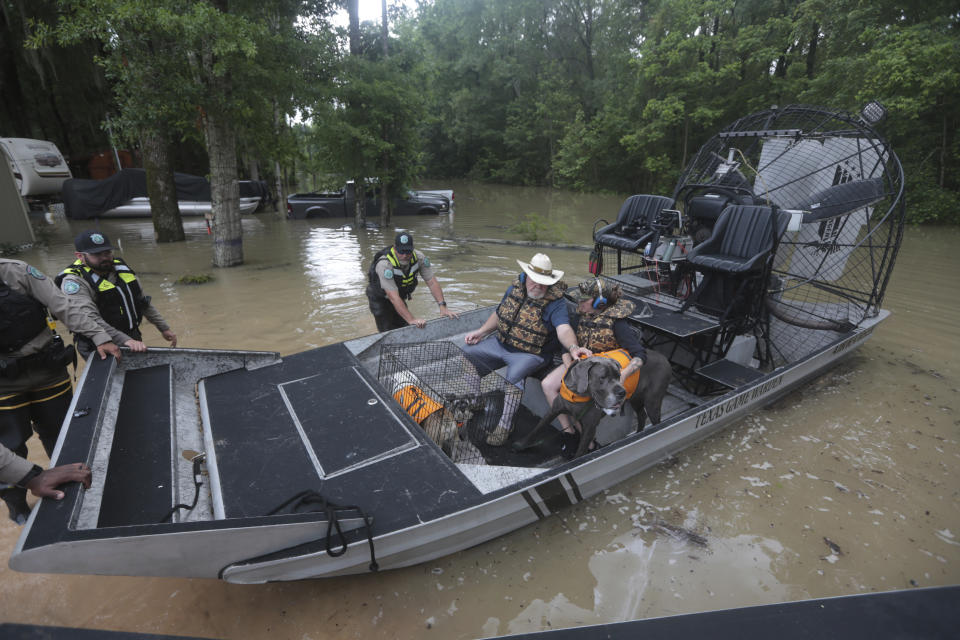 Texas Parks & Wildlife Department game wardens use a boat to rescue residents from floodwaters in Liberty County, Texas, on Saturday, May 4, 2024. (AP Photo/Lekan Oyekanmi)