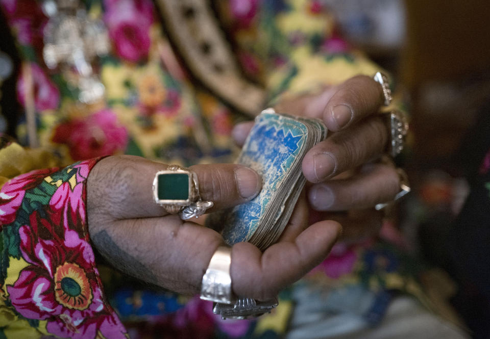 Zoltan Sztojka, traditional Gypsy fortune-teller holding his cards in his hand in Soltvadkert, central Hungary on Oct. 10, 2021. Sztojka, by his own account Hungary’s last Roma fortuneteller, is working to preserve his culture's traditions that are slowly vanishing in the Central European country. (AP Photo/Bela Szandelszky)