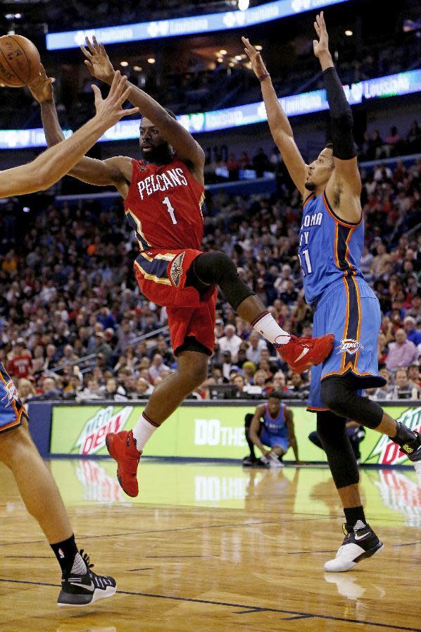 New Orleans Pelicans guard Tyreke Evans (1) passes the ball after being blocked at the basket by Oklahoma City Thunder forward Andre Roberson (21) during the second half of an NBA basketball game in New Orleans, Wednesday, Dec. 21, 2016. (AP Photo/Max Becherer)