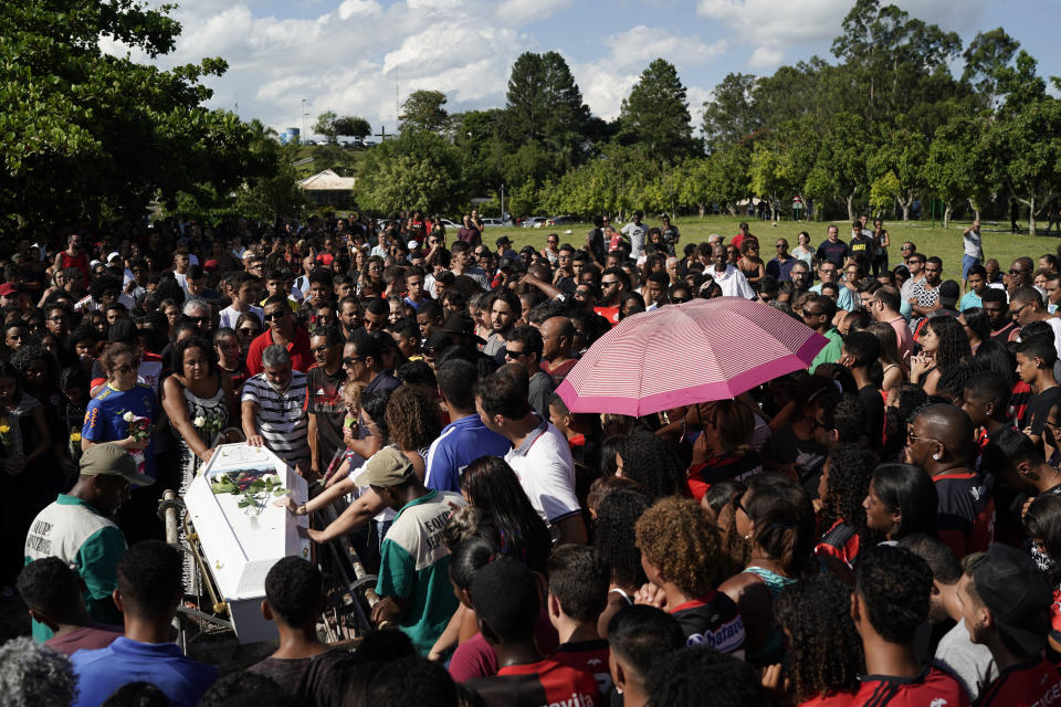 Friends and relatives grieve during the burial of the young soccer player Arthur Vinicius, one of the victims of a fire at a Brazilian soccer academy, in Volta Redonda, Brazil, Saturday, Feb. 9, 2019. A fire early Friday swept through the sleeping quarters of an academy for Brazil's popular professional soccer club Flamengo. (AP Photo/Leo Correa)