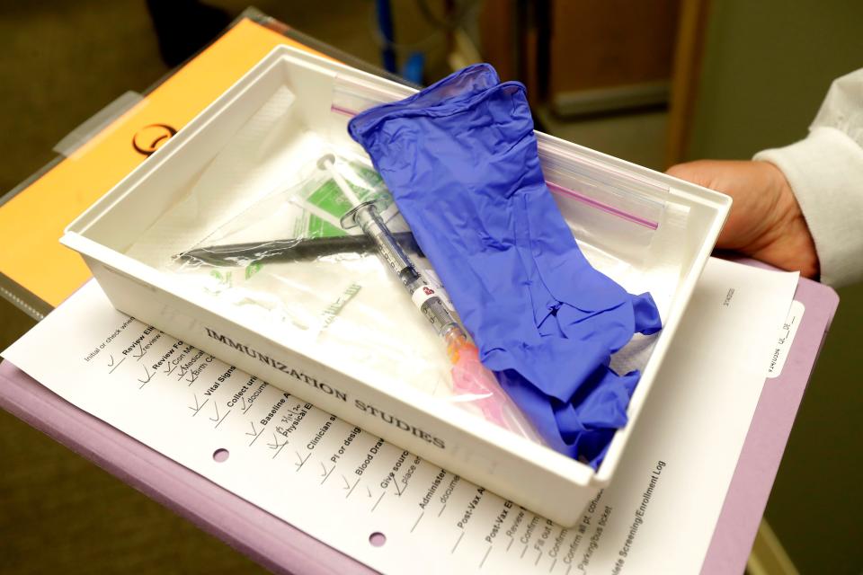 Pharmacist Michael Witte holds a tray with a syringe containing a shot that will be used in the first-stage safety study clinical trial of the potential vaccine.