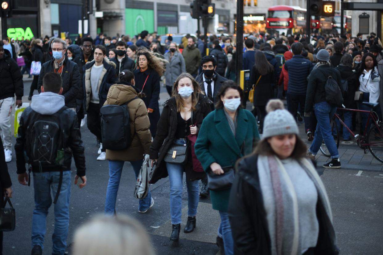 Shoppers, some wearing face-masks, walk along Oxford Street in central London on December 4, 2021, as compulsory mask wearing in shops has been reintroduced in England as fears rise over the Omicron variant of Covid-19. (Photo by Daniel LEAL / AFP) (Photo by DANIEL LEAL/AFP via Getty Images)