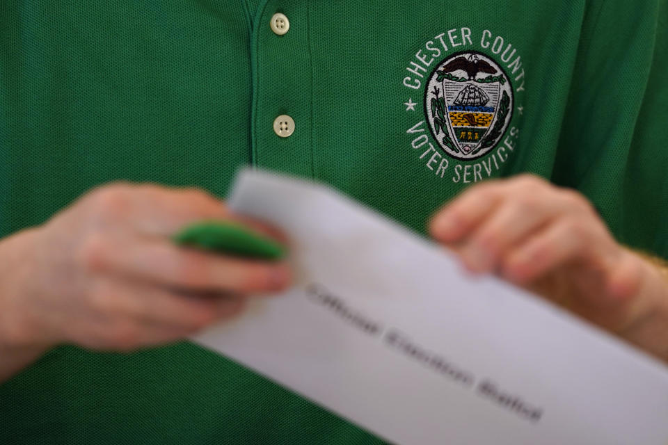 A Chester County election worker processes a ballot for the Pennsylvania primary election at the Chester County Voter Services office, Thursday, May 19, 2022, in West Chester, Pa. (AP Photo/Matt Slocum)