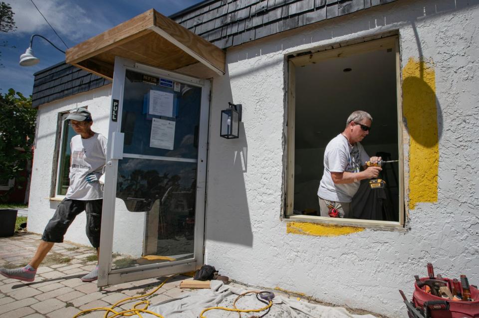 Dawn Keune and Greg Mulkey collaborate to install a new window while working on a building in Matlacha Monday, September 25, 2023. Almost a year after Hurricane Ian impacted the area, businesses are still in the process of recovery.