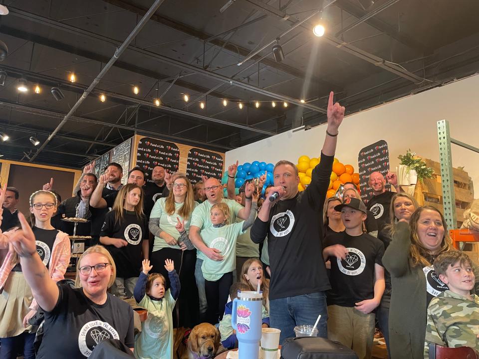 Fund A Life founder Mark Howell (center) celebrates granting more than $1 million to others facing life-altering challenges on Tuesday, March 19.