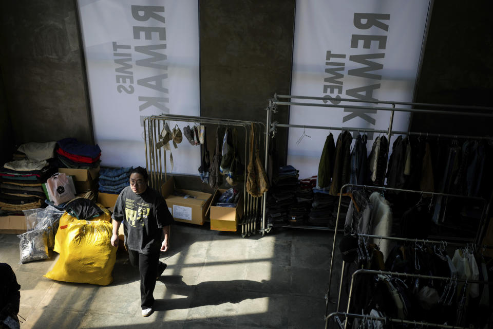 Thirty-year-old designer Da Bao, who founded Times Remake, a Shanghai-based brand that takes secondhand clothes and refashions them into new garments, works in the work room in Shanghai, Tuesday, March 19, 2024. (AP Photo/Ng Han Guan)