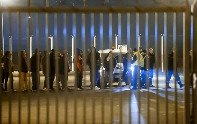 Security agents escort migrants after their intrusion in the Eurotunnel site in Coquelles, northern France, on October 3, 2015