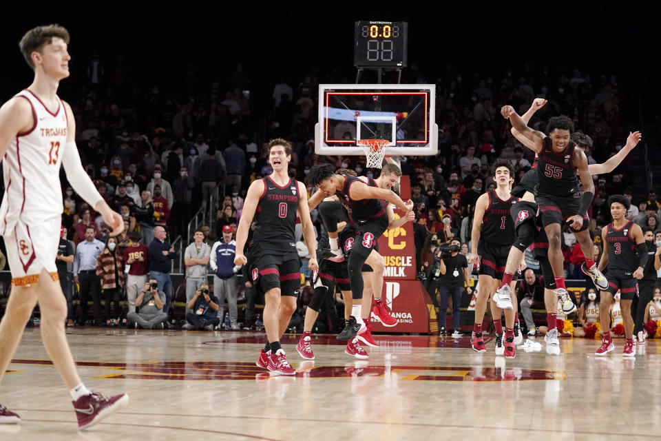 Members of the Stanford team celebrate as Southern California guard Drew Peterson walks off the court after defeating USC 64-61 in an NCAA college basketball game Thursday, Jan. 27, 2022, in Los Angeles. (AP Photo/Mark J. Terrill)
