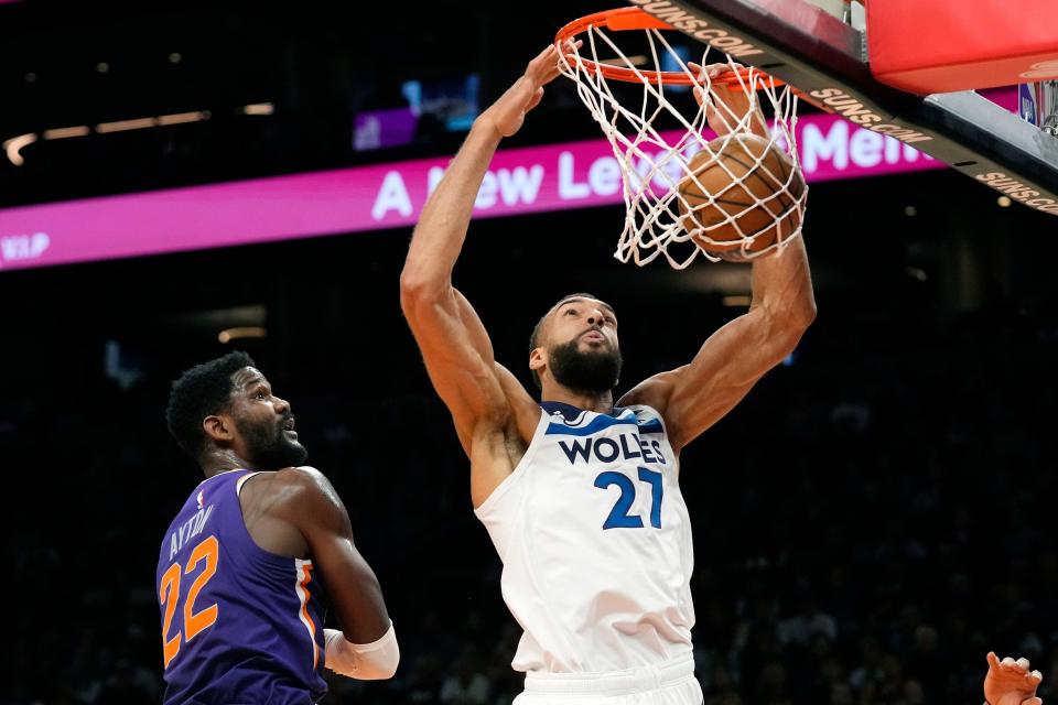 Minnesota Timberwolves center Rudy Gobert (27) dunks against Phoenix Suns center Deandre Ayton (22) during the first half in Phoenix.