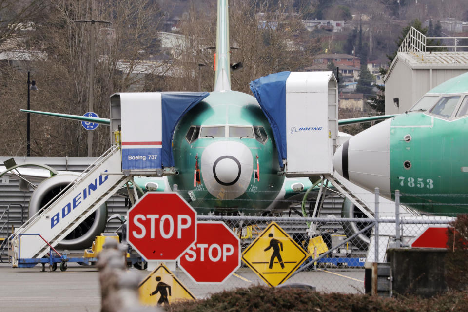 Boeing 737 MAX jets sit parked Monday, Dec. 16, 2019, in Renton, Wash. Boeing Co. will temporarily stop producing its grounded 737 MAX jet starting in January as it struggles to get approval from regulators to put the plane back in the air. The company says it will halt production at the plant with 12,000 employees in Renton, near Seattle. (AP Photo/Elaine Thompson)